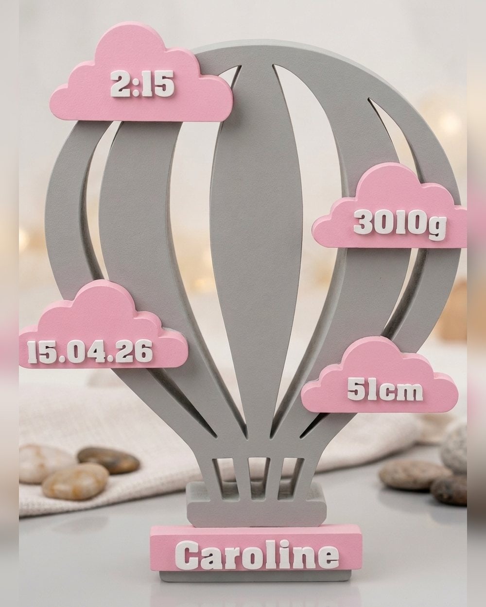 Balão de nascimento com nuvens rosa mostrando data, hora, peso e comprimento, e o nome Caroline na base